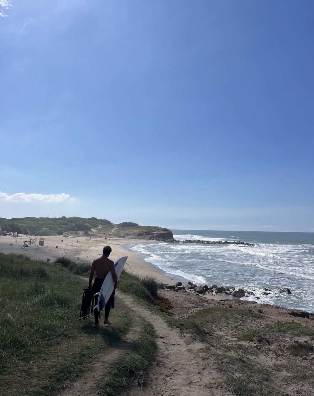 Surfista caminando hacia la playa