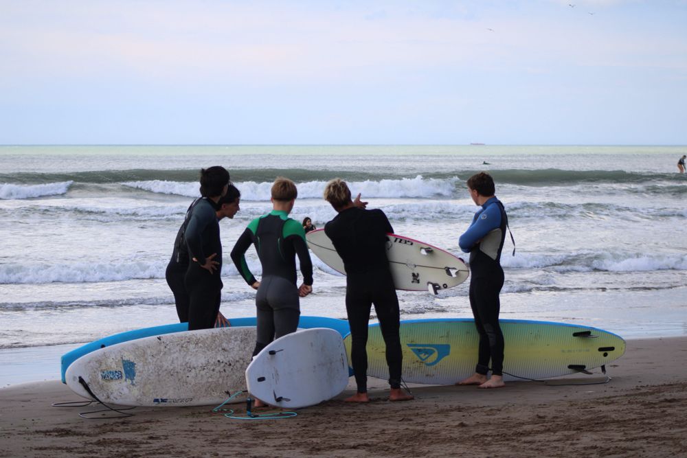 Instructor explicando a un grupo frente al mar
