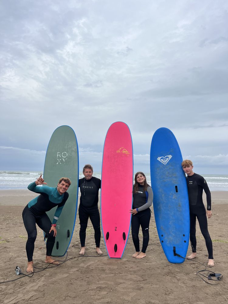 Alumnos con tablas de colores en la playa