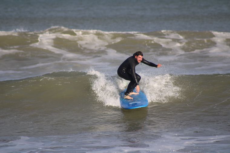 Alumno surfeando de frente a la cámara
