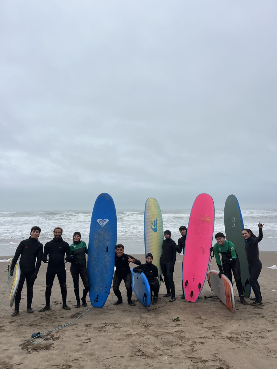 Alumnos con tablas de colores en la playa